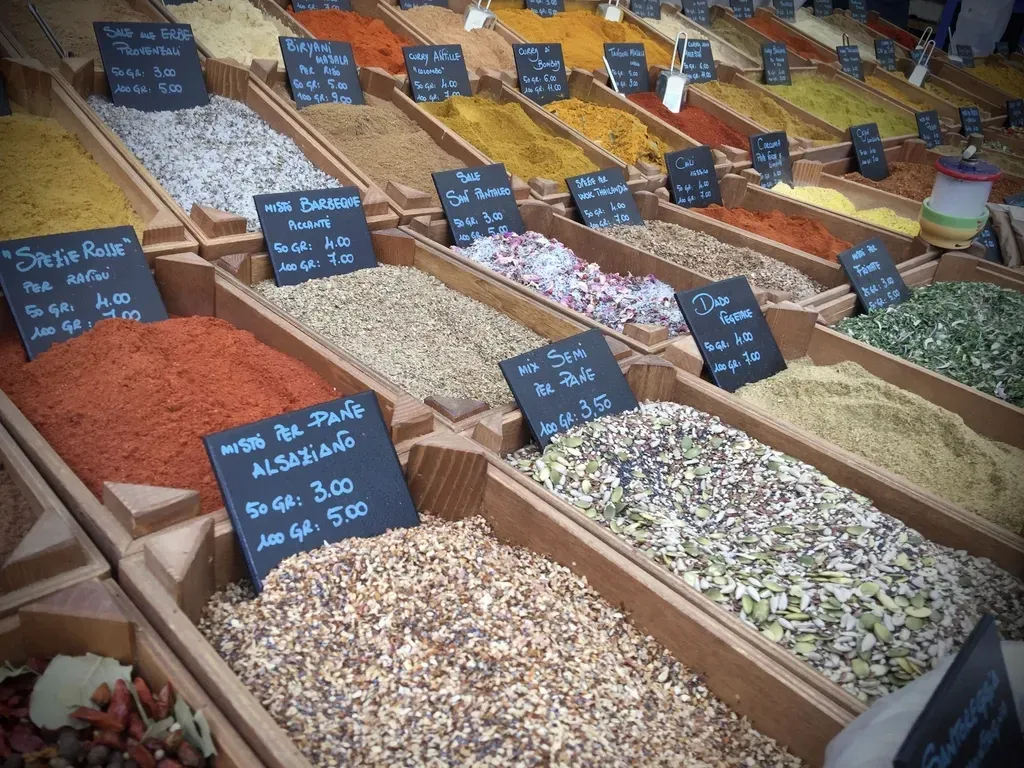 Market stalls with goods in bins and price cards