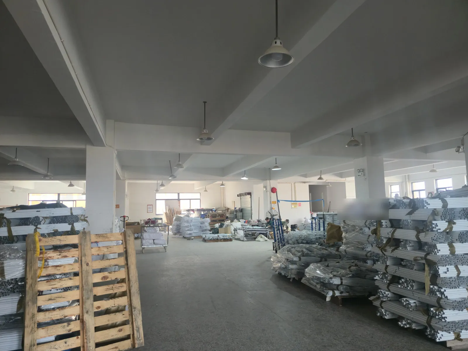 Bundled aluminium umbrella poles strapped onto pallets in the warehouse