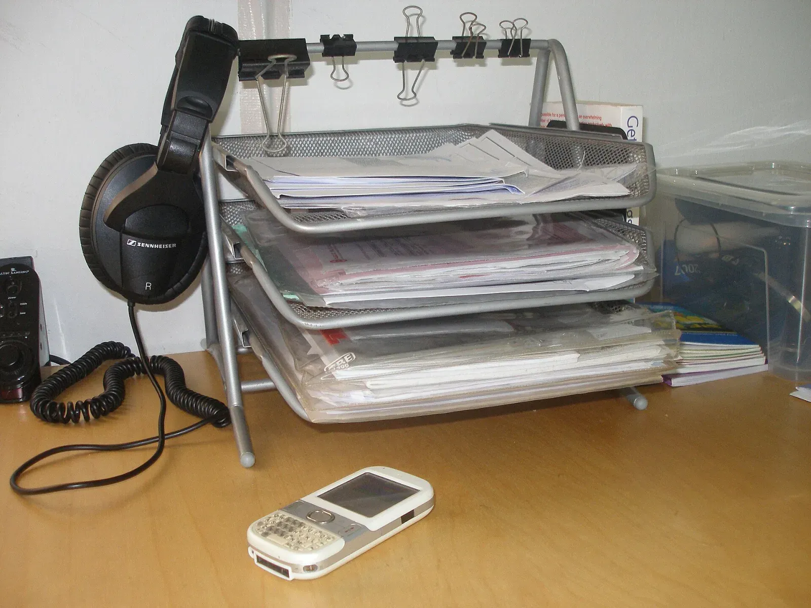 Stacked document trays holding supplier contracts, invoices and bank forms on an office desk